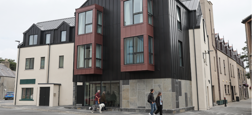 a shot of The Albert Hotel’s exterior, with four people walking outside the building
