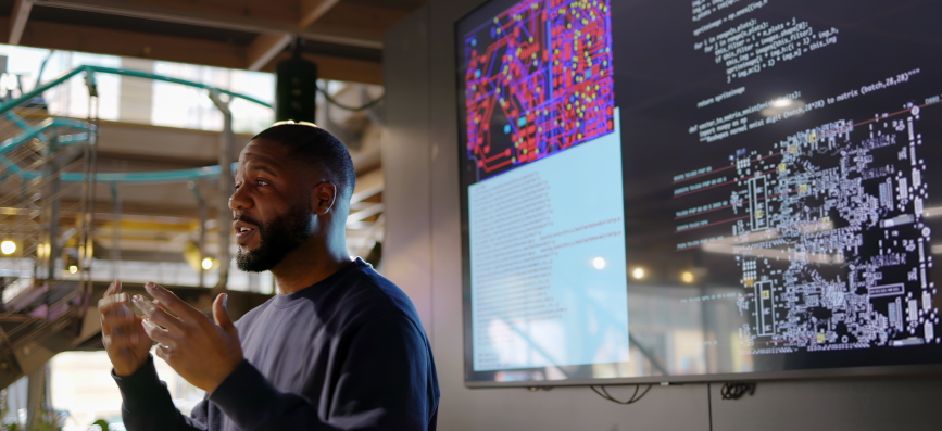 This image shows a man in front of a screen. 
