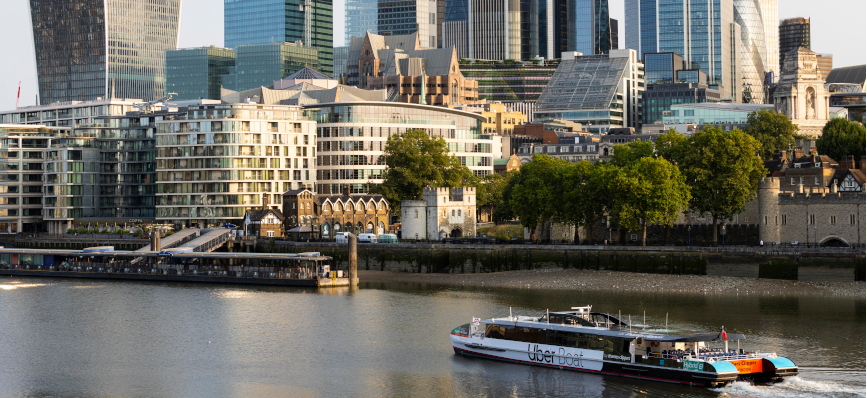 Uber boat on river Thames with skyscrapers in background