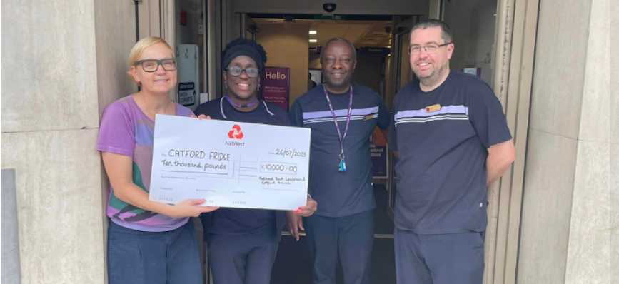 Colleagues from our Lewisham branch holding a cheque with their donation of £10,000 for the Catford Fridge.  