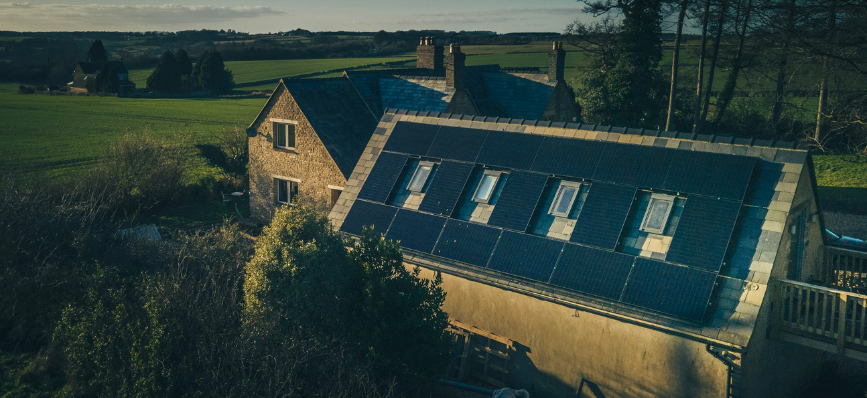 A house in the countryside with solar panels on its roof