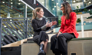 Two colleagues on a bench in office in discussion