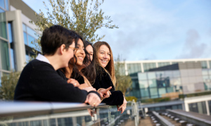 This image shows four NatWest Group employees together outside. They are leaning on a rail looking out at a view.