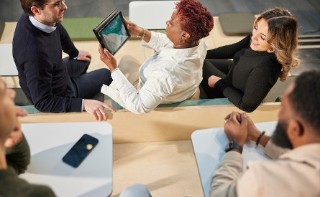 Group of colleagues at a table looking at a tablet