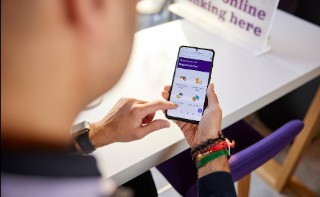 View from above of hands using a phone to find banking services