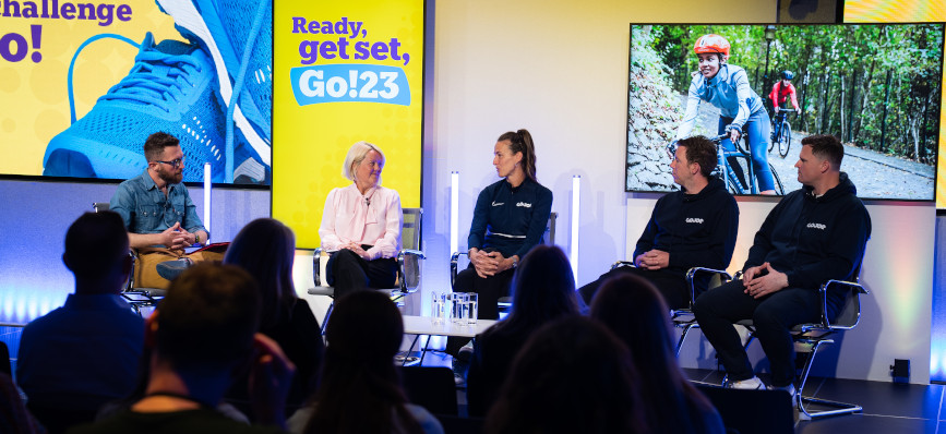 Men and women sitting on stage discussing Go!23 launch.