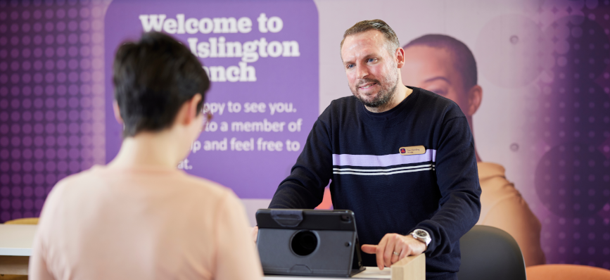 Colleague supporting customer at front desk in NatWest branch