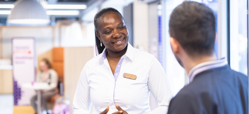NatWest female colleague smiling at male colleague in branch environment