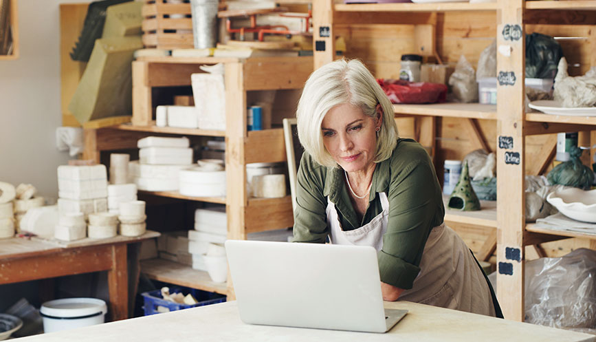 Someone in a workshop looking at their laptop