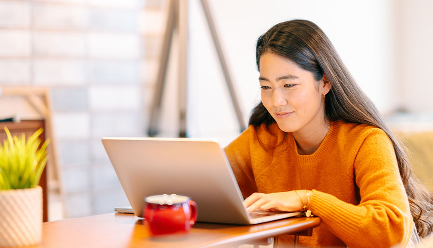 Woman using laptop in cafe