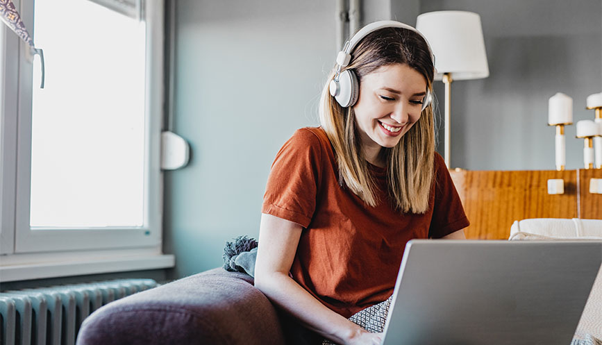 Woman with earphones working on laptop