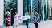Women in Business partners with Ulster Bank - four women holding a Young Women's Network banner outside an Ulster Bank building