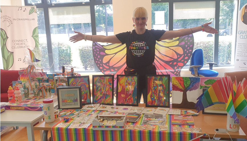 Ann Harris at a table of assorted rainbow items