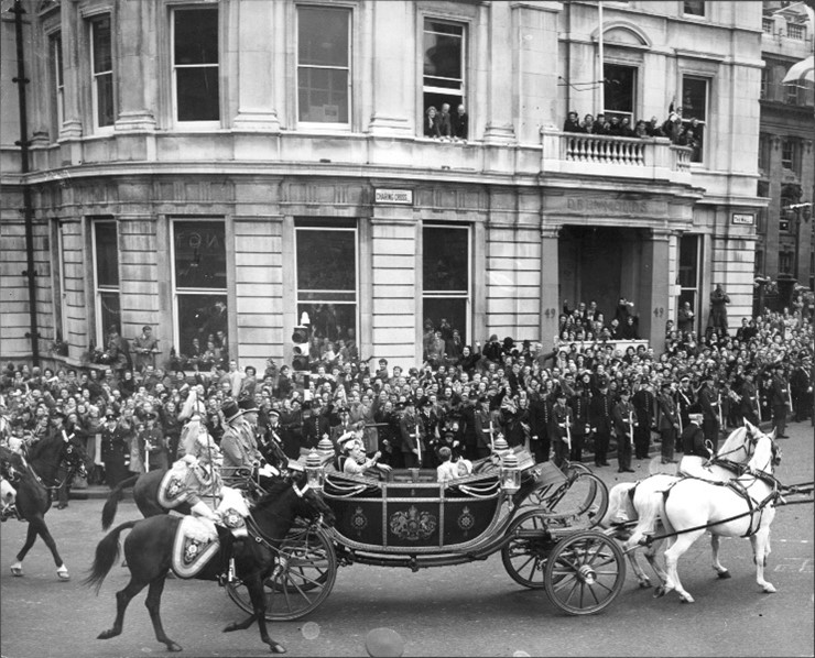 Black and white image of a carriage passing through crowds