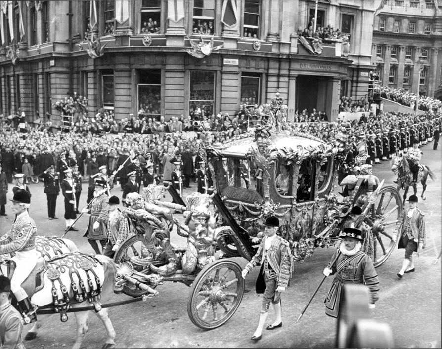 Black and white imagine of a carriage passing through crowds