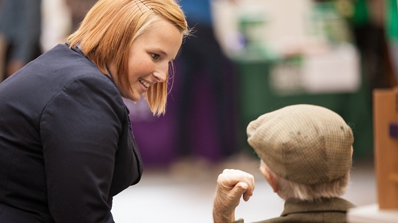 NatWest Group staff member smiling and speaking to the elderly
